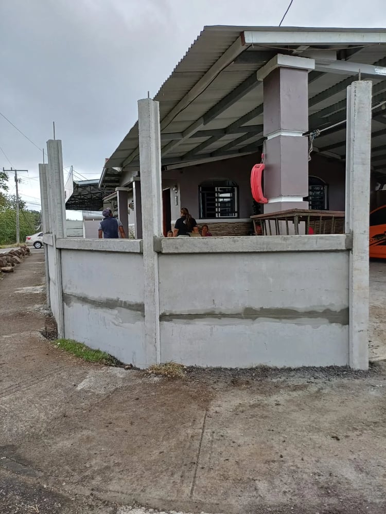 Muro perimetral URBEXA alto en frente urbano de residencia con techo de teja